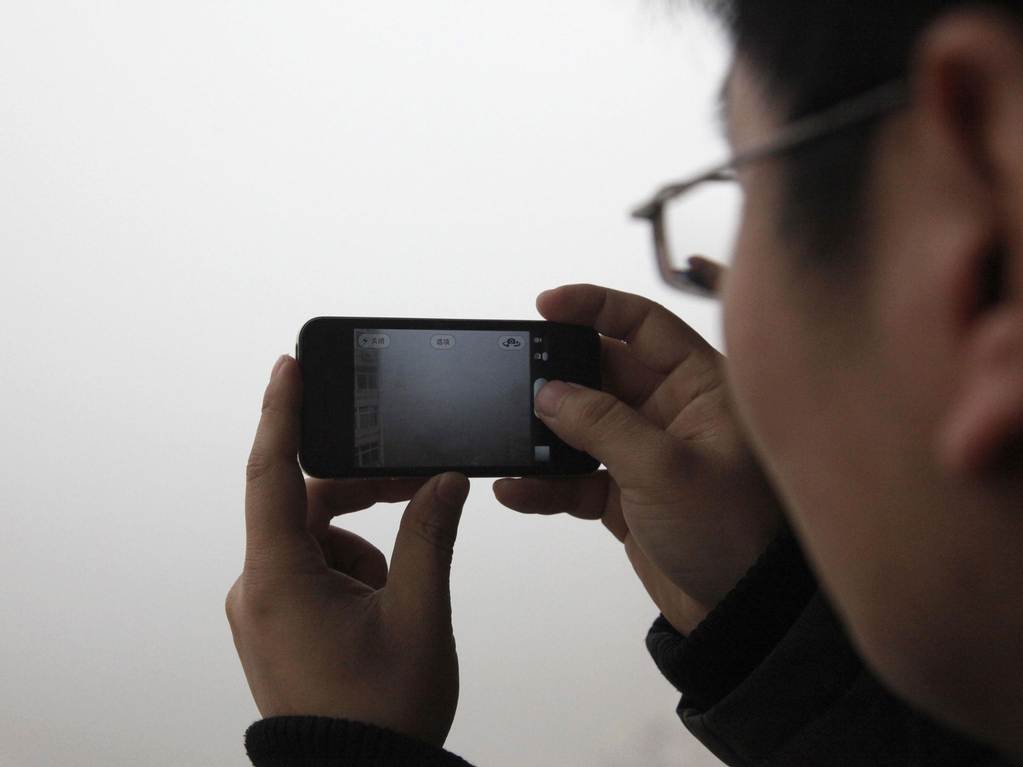 A man takes a photo of heavy smog in Qingdao, east China's Shandong province