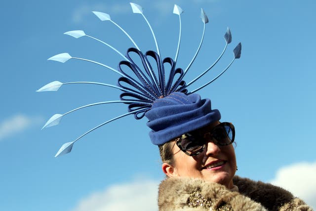 One lady wears a striking hat styled like a peacock's tail feathers