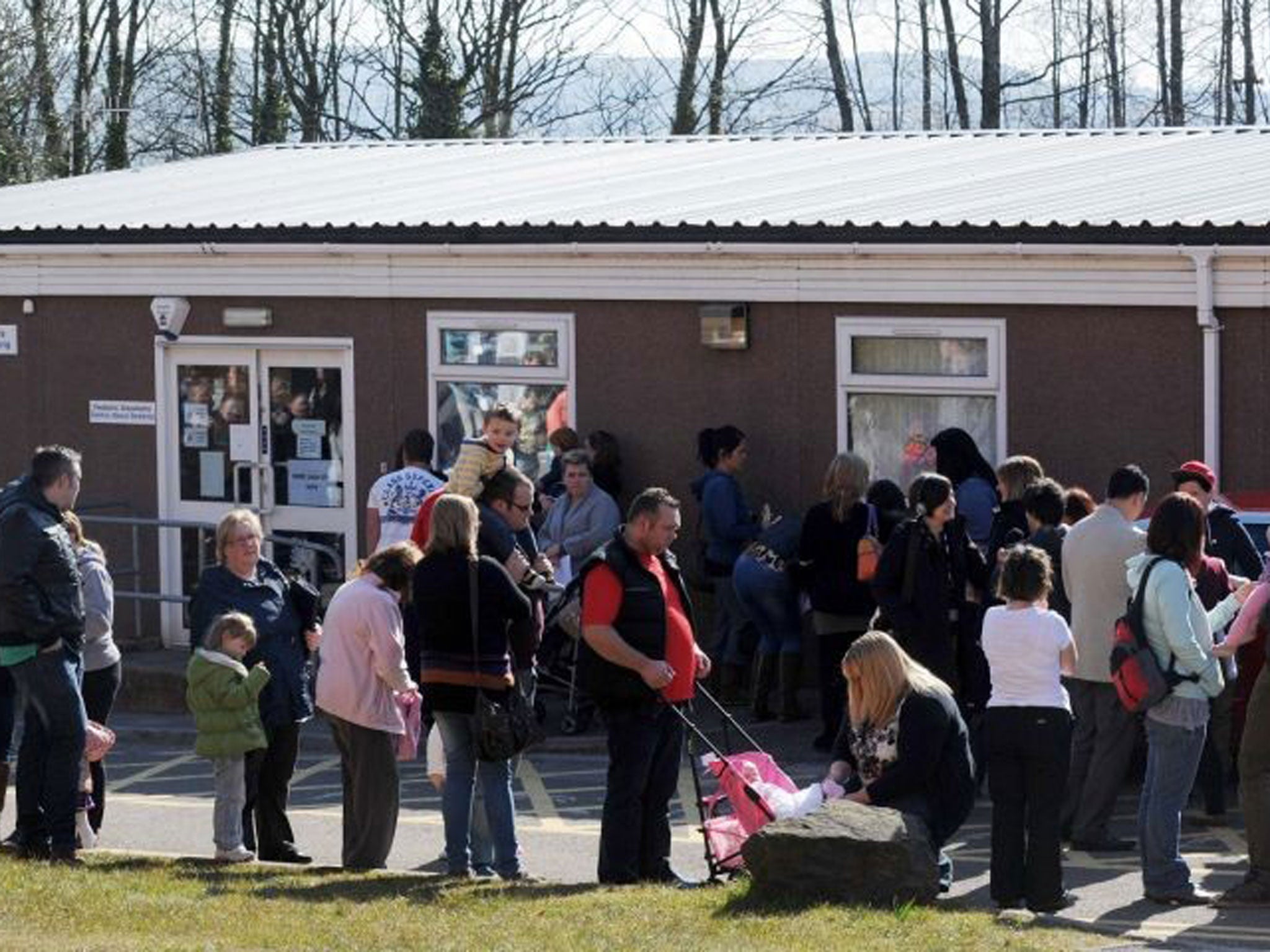 Parents and children queue outside the Paediatric Outpatient department at Morriston Hospital in Swansea