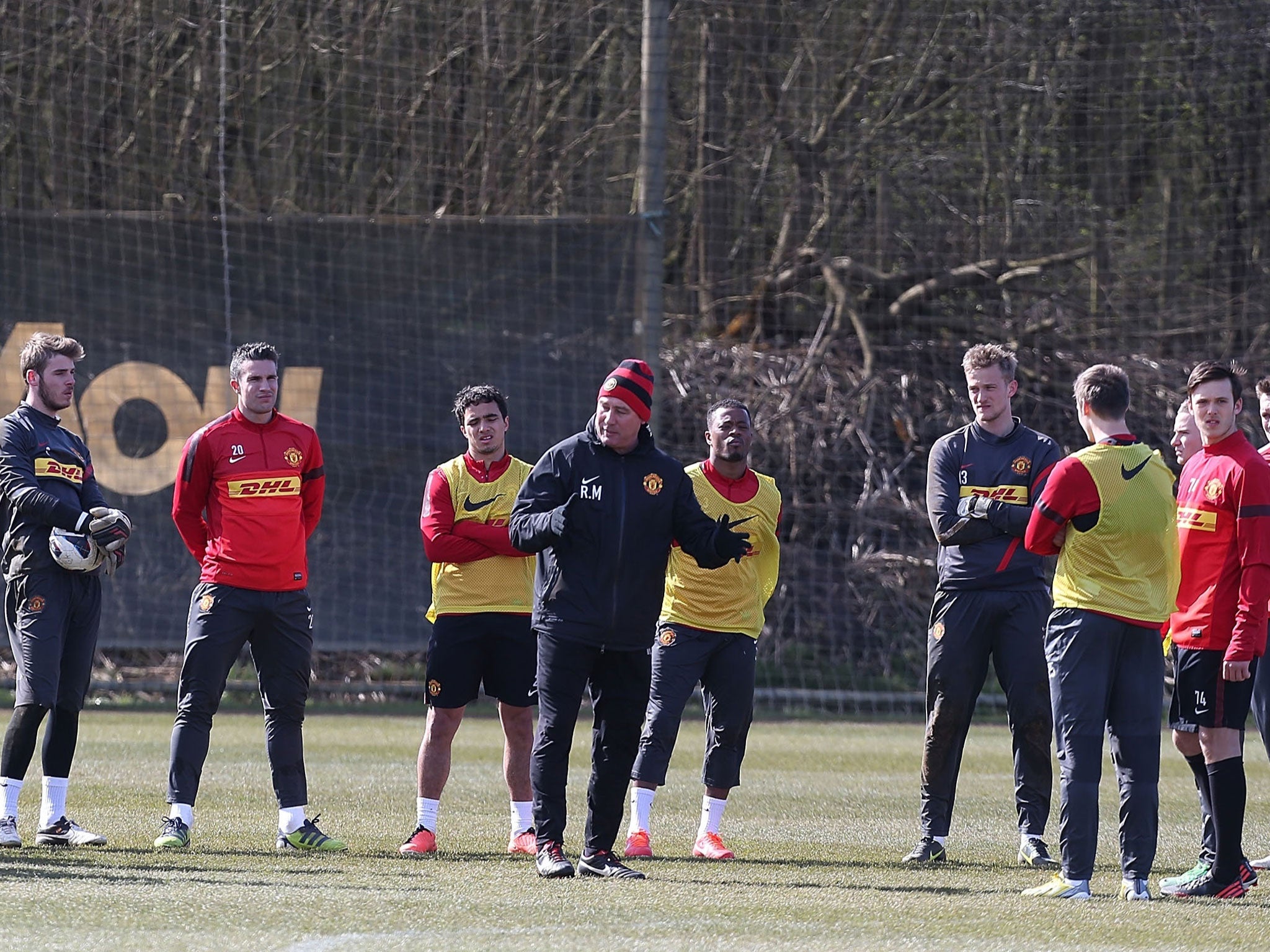 United we stand: Rene Meulensteen (centre), first-team coach of the champions-elect, talks to the squad during a session at their Carrington training ground on Friday