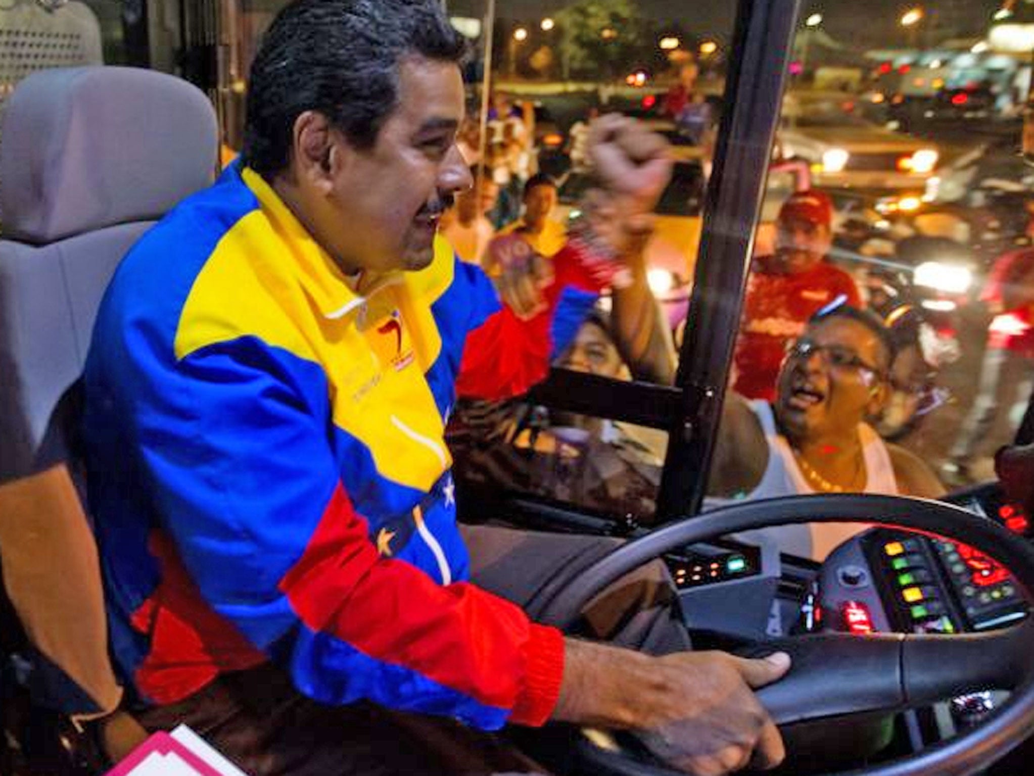 Venezuelan acting president and presidential candidate Nicolas Maduro drives a bus during an electoral campaign