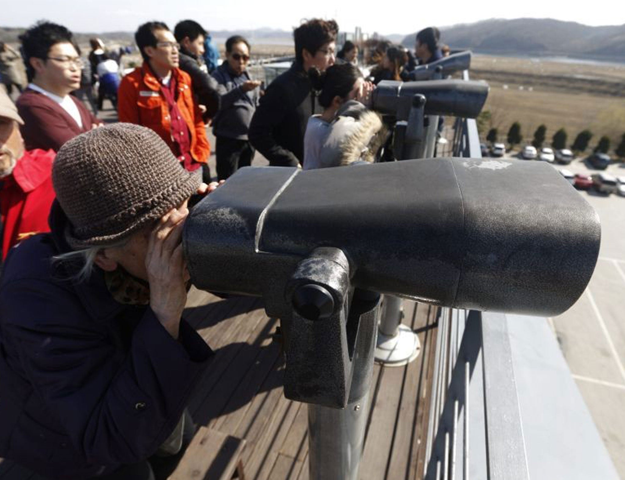 South Koreans look north through binoculars near the demilitarized zone