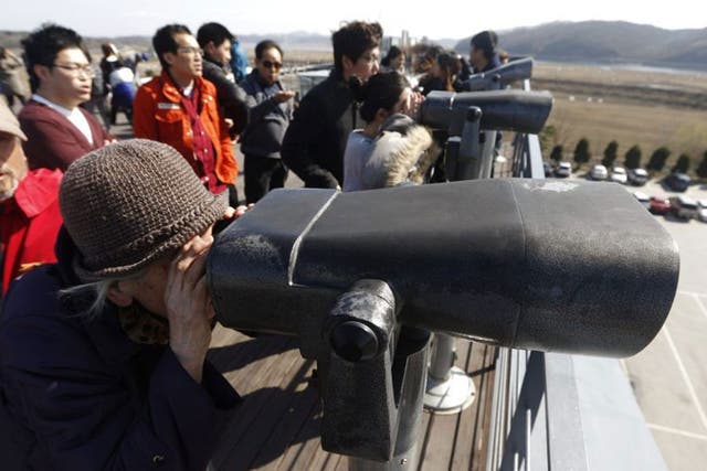 South Koreans look north through binoculars near the demilitarized zone 