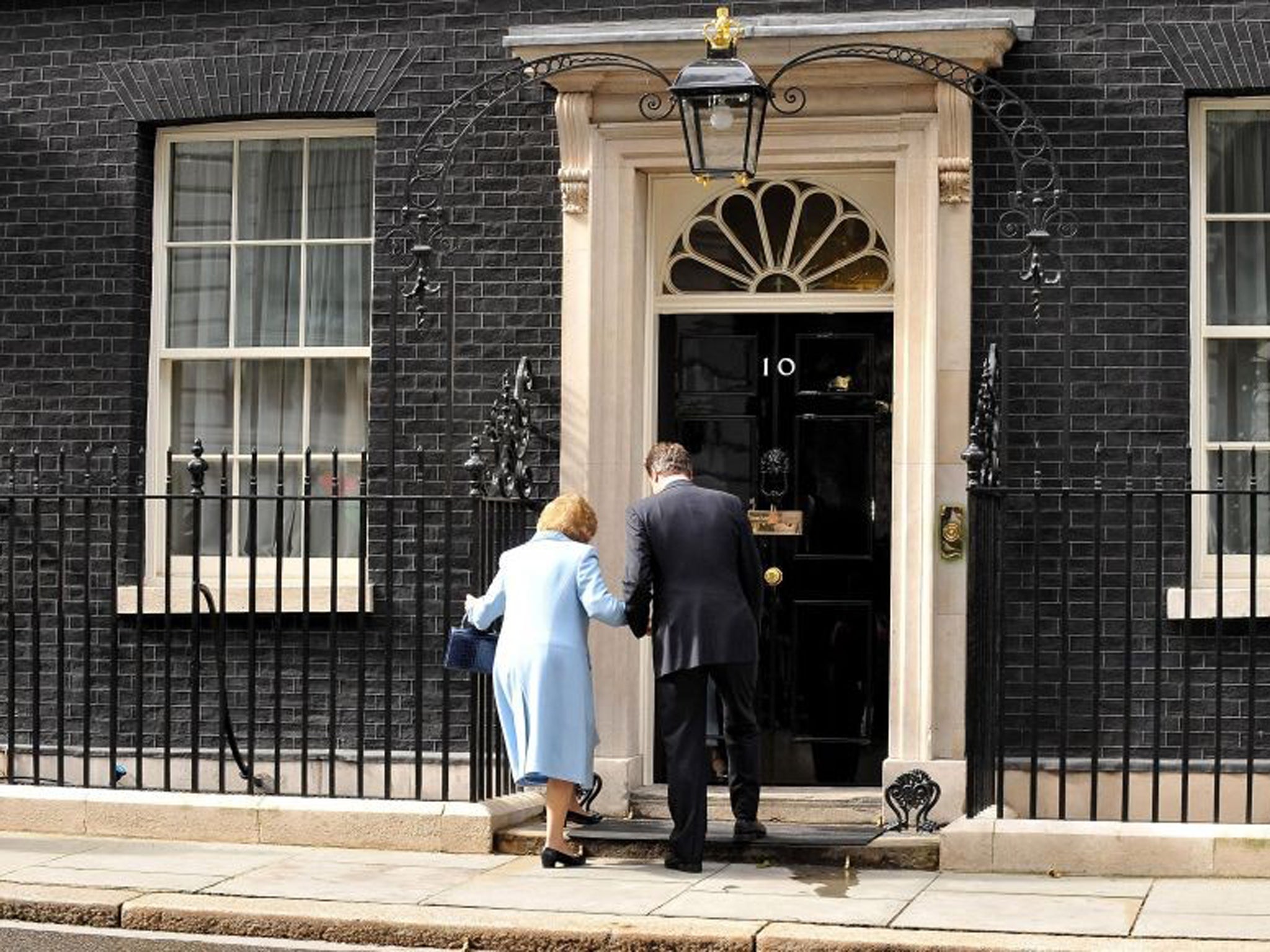 June 2010: Prime Minister David Cameron helps Baroness Thatcher into 10 Downing Street