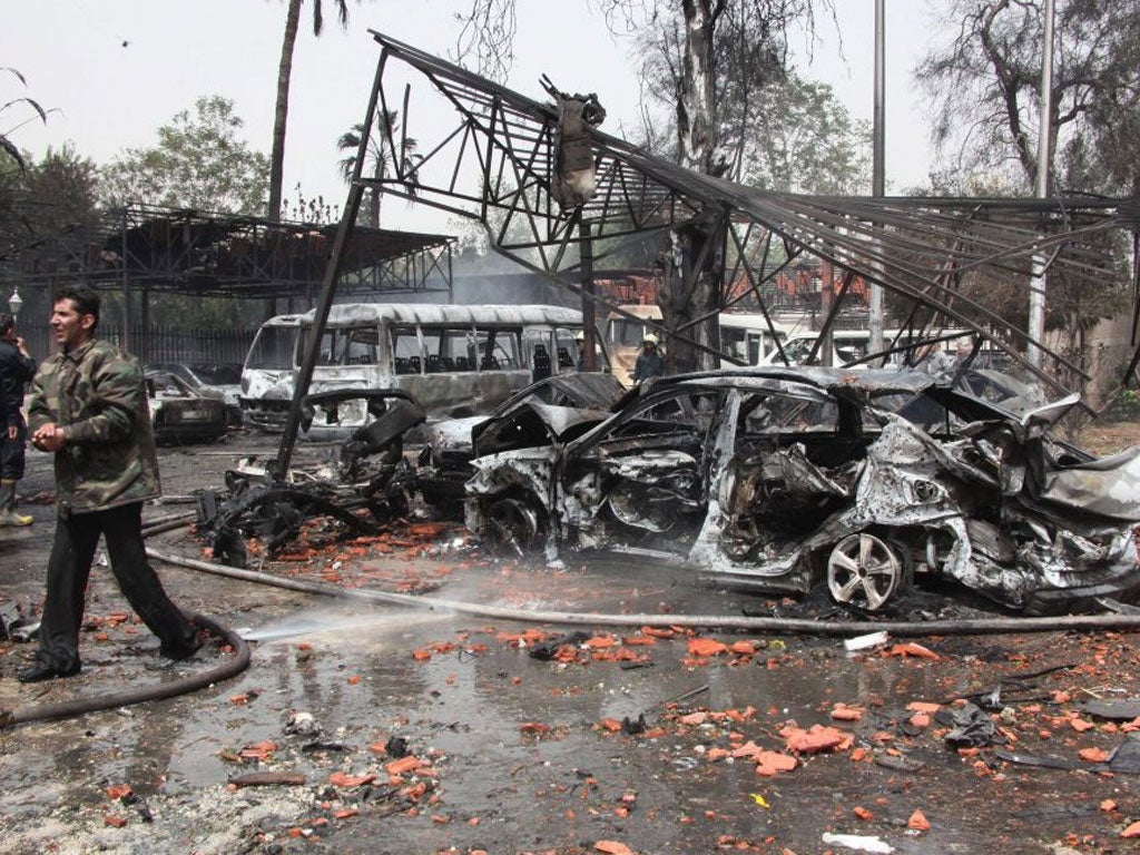 Burned cars are seen at the site of car bomb explosion in Damascus, Syria