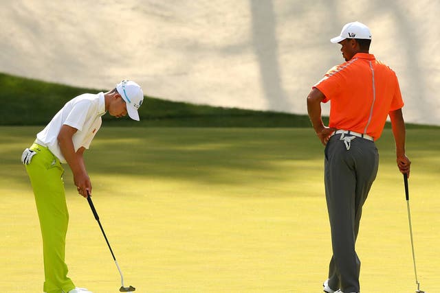Tianland Guan practices alongside Tiger Woods at Augusta
