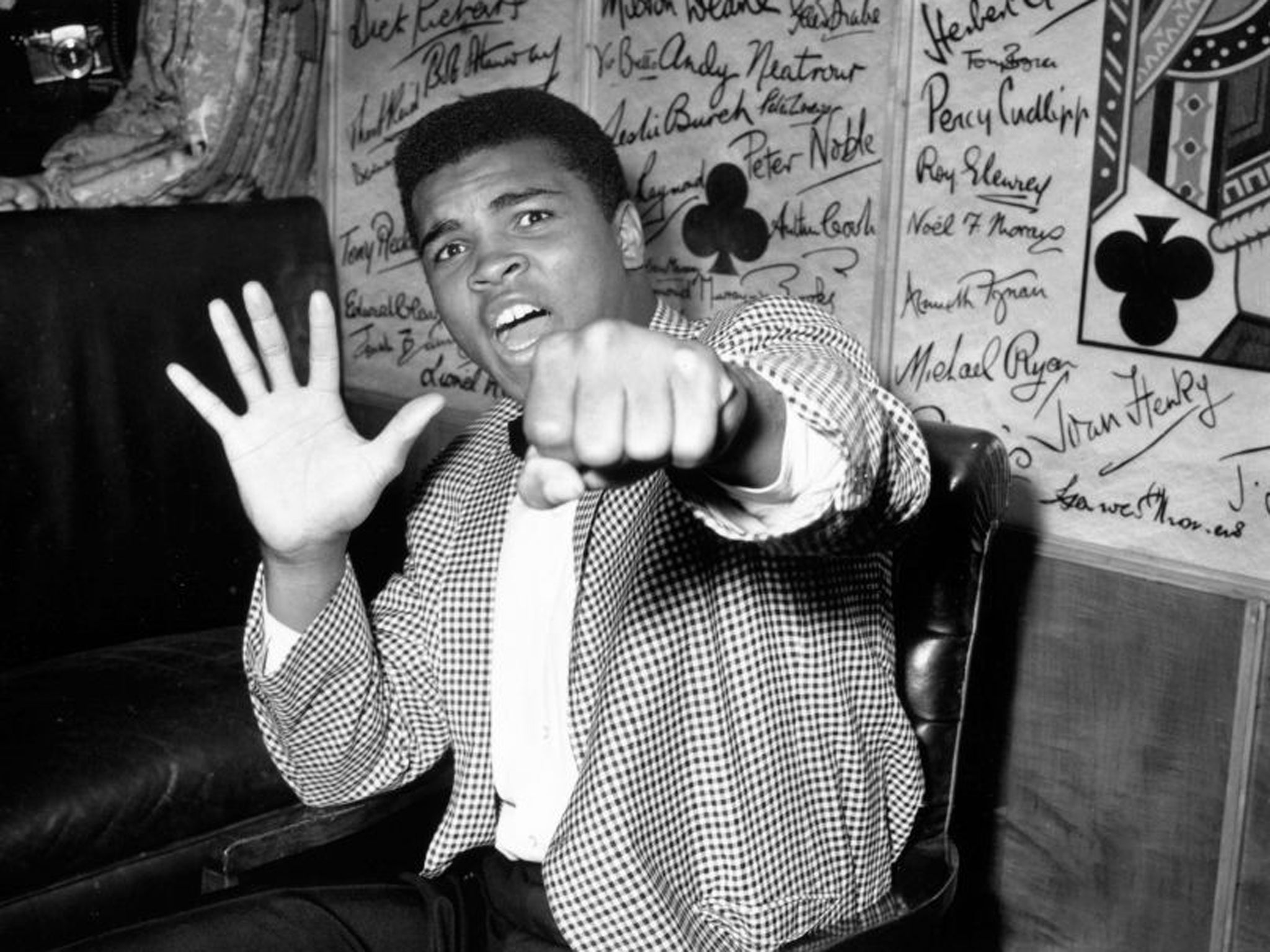 June 1963: A supremely confident Muhammad Ali holds up five fingers in a prediction of how many rounds it will take him to knock out British boxer Henry Cooper