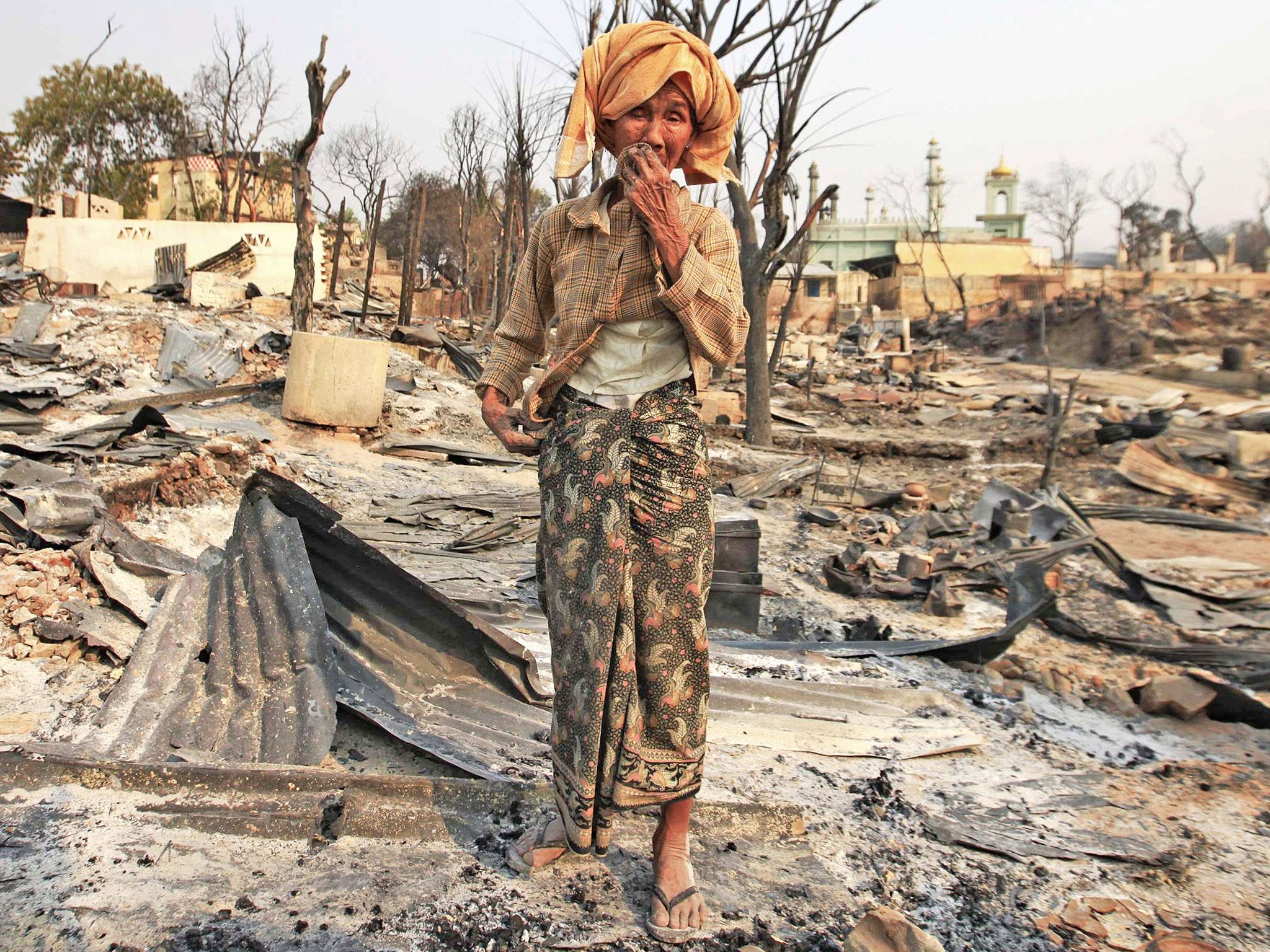 A woman cries for her home, burnt down during the riot in Meiktila in March