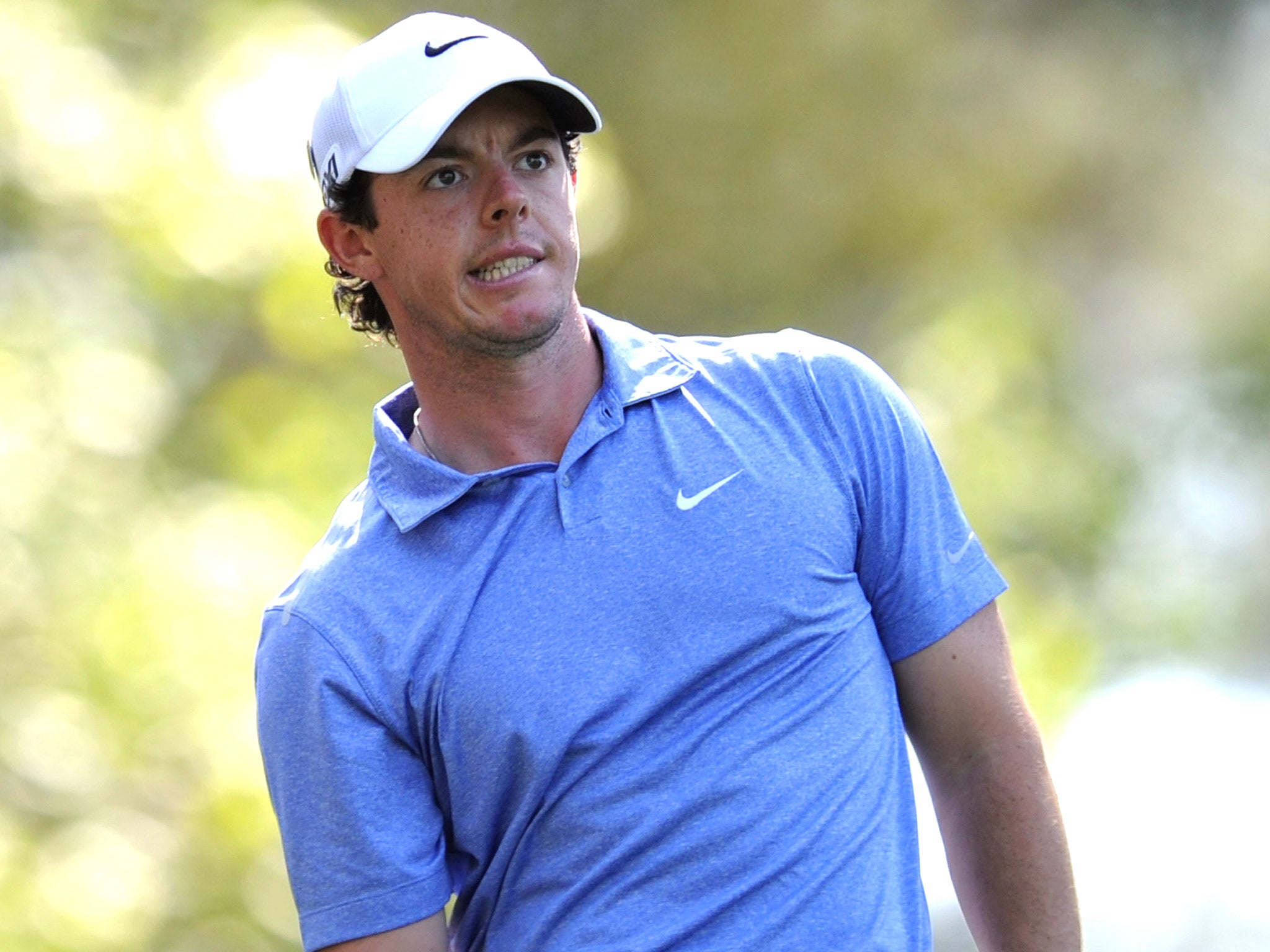 Rory McIlroy watches his ball on the course during practice