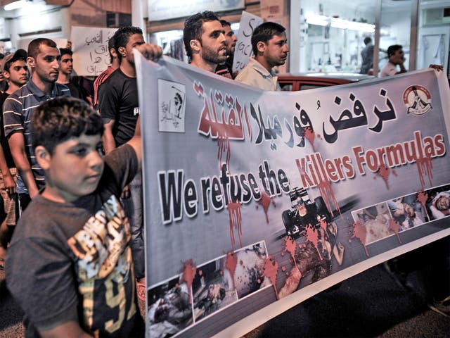 Bahrainis hold placards in solidarity with jailed political activists and against the upcoming Bahrain Formula One Grand Prix