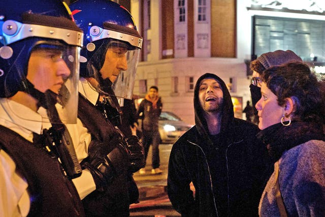 Police speak to protesters during Monday night's unrest in Brixton