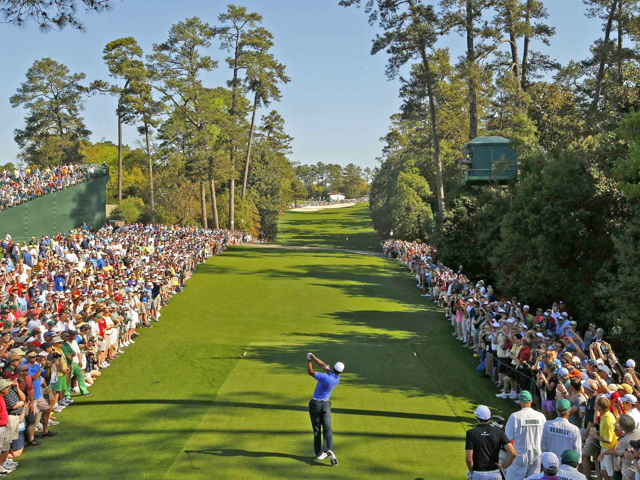 Massed galleries watch Tiger Woods drive on the 18th hole during a practice round for the Masters at Augusta yesterday