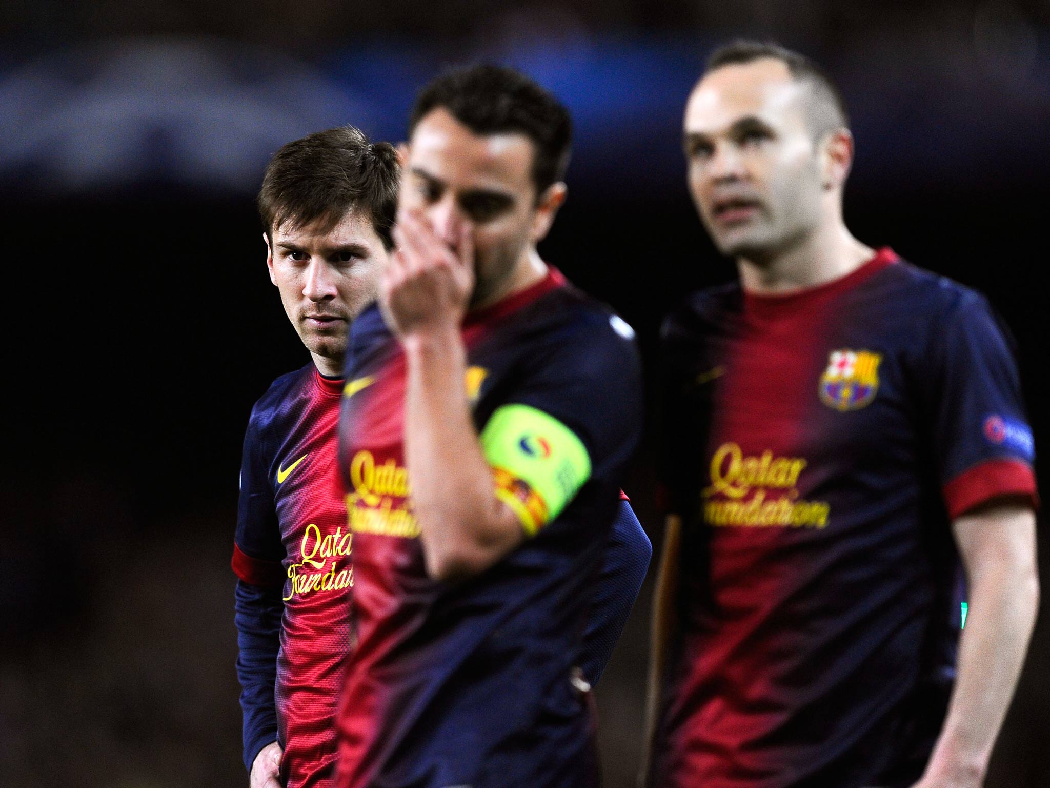 Lionel Messi behind team-mates Xavi and Iniesta