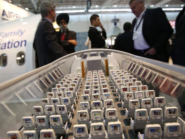 Visitors look at a scale model of an Airbus A350 at the Aircraft Interiors Expo 2013 in Hamburg