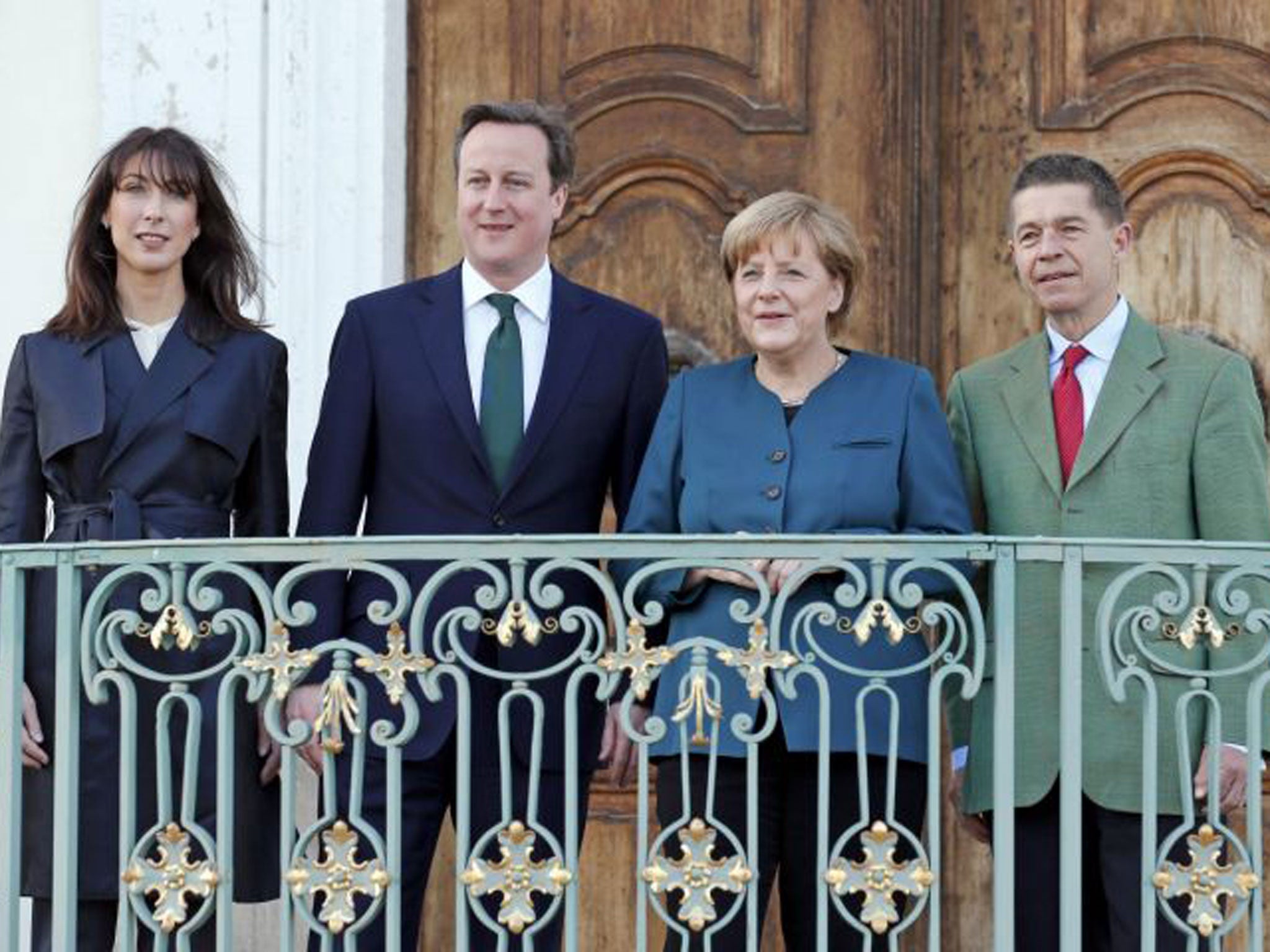 German Chancellor Angela Merkel and her husband Joachim Sauer (R) welcome Britain’s Prime Minister David Cameron and his wife Samantha (L) at the government’s guest house Schloss Meseberg