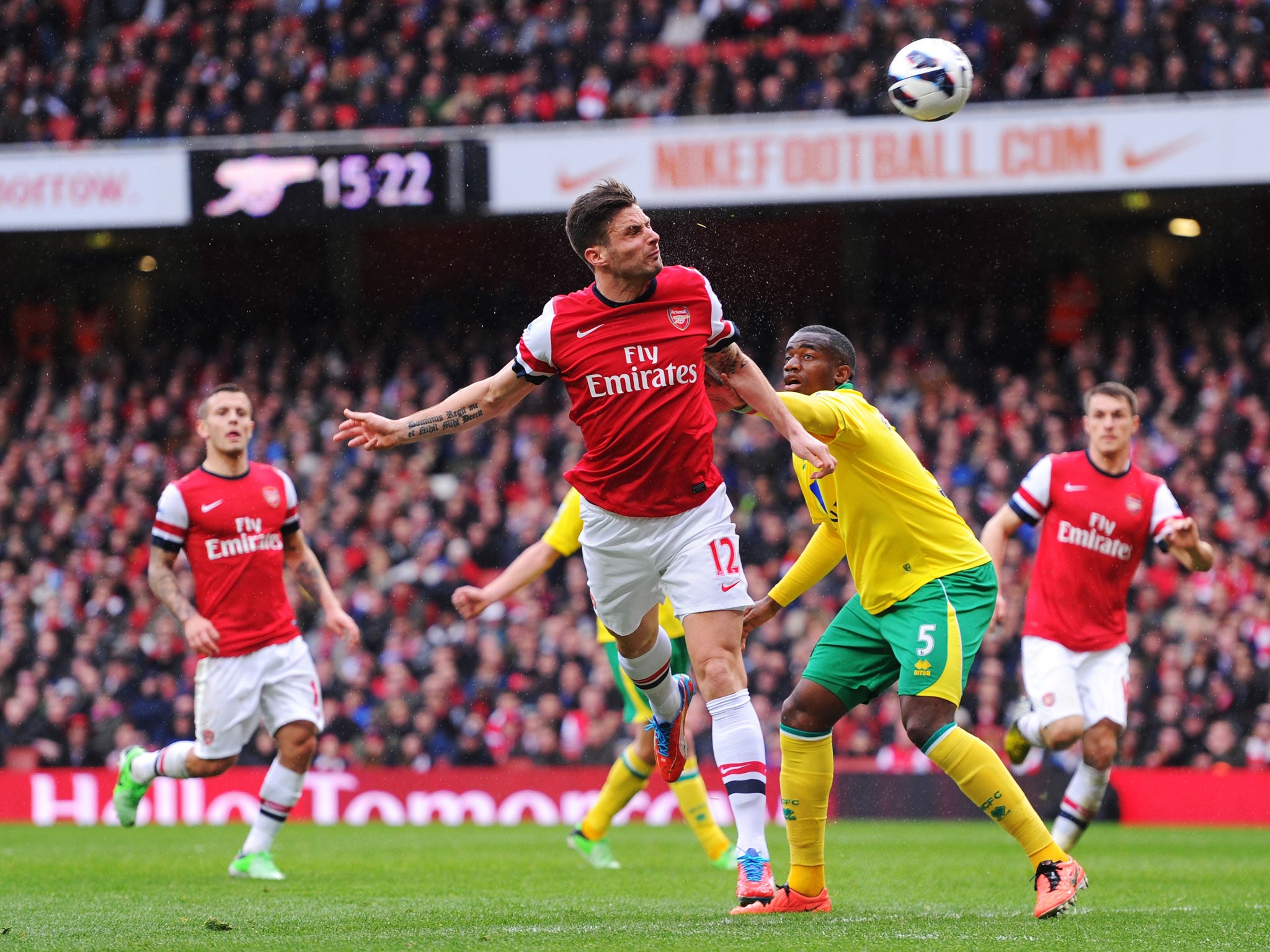 Olivier Giroud of Arsenal and Sebastien Bassong of Norwich City compete for the ball