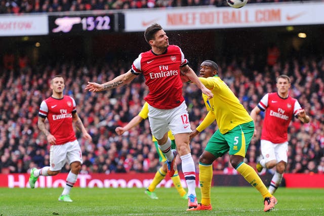 Olivier Giroud of Arsenal and Sebastien Bassong of Norwich City compete for the ball