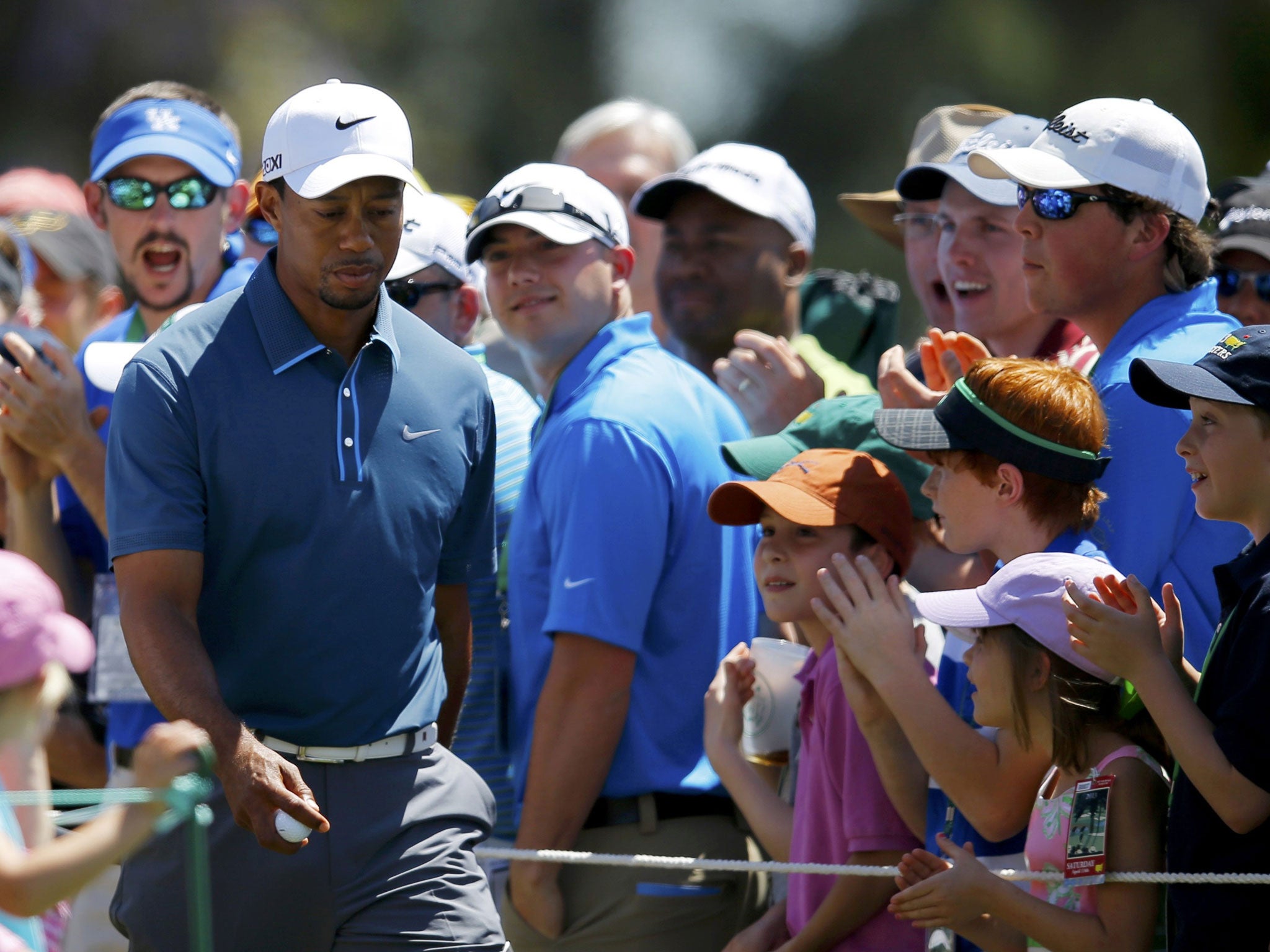 Walk of defiance: Tiger Woods strides on to the first tee yesterday