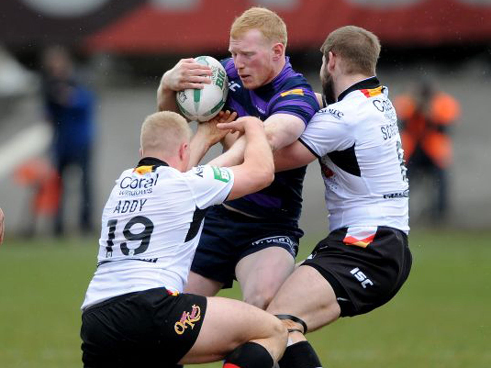 Wigan’s Liam Farrell is held up by Danny Addy and Nick Scruton