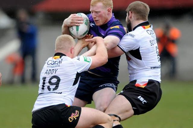 Wigan’s Liam Farrell is held up by Danny Addy and Nick Scruton