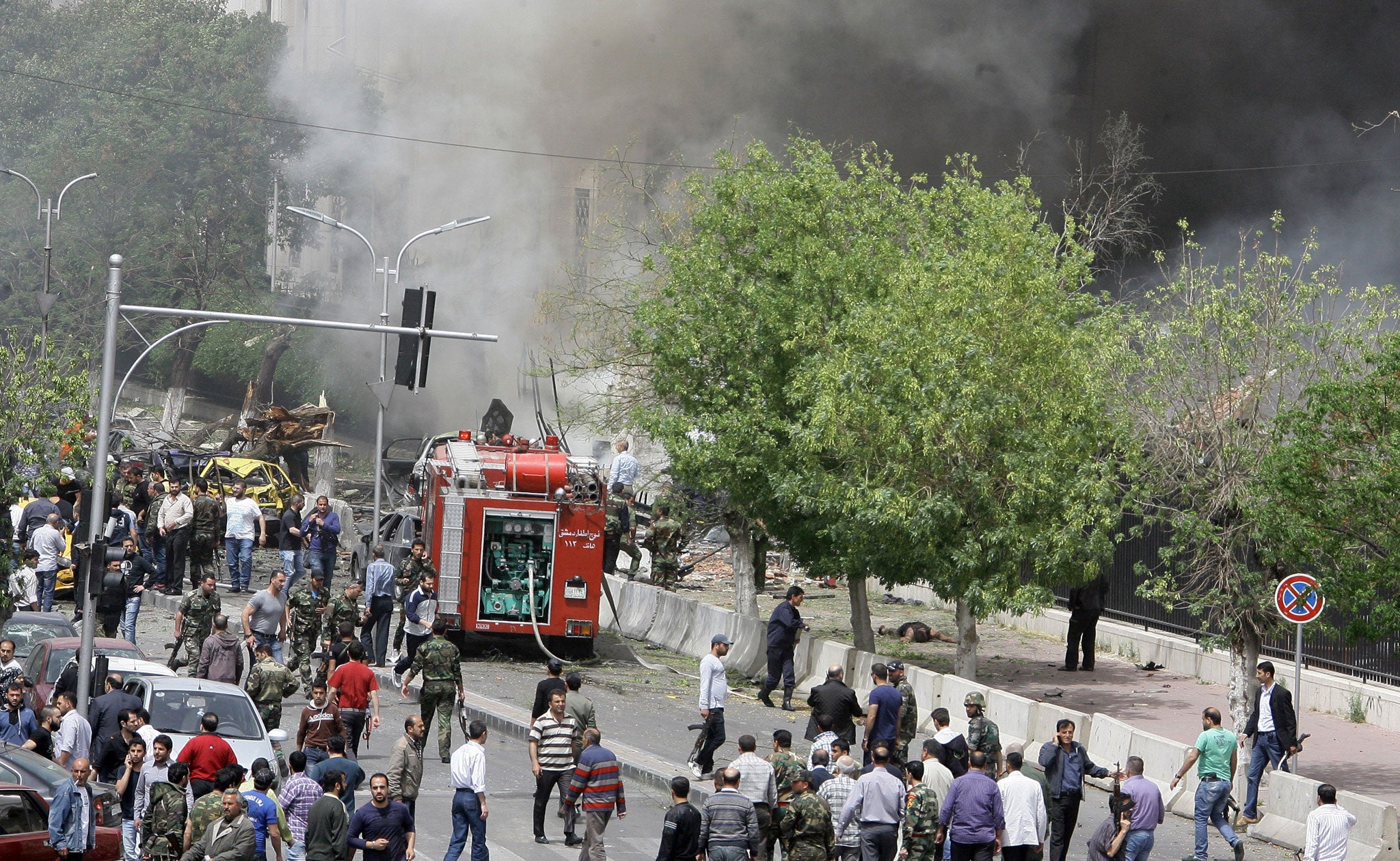 People inspect the scene of a deadly car bomb explosion which rocked central Damascus on April 8, 2013