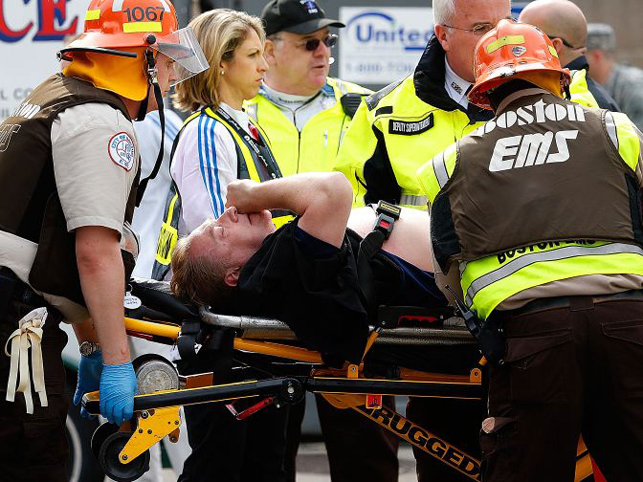 A man is loaded into an ambulance after he was injured by one of two bombs exploded during the 117th Boston Marathon near Copley Square