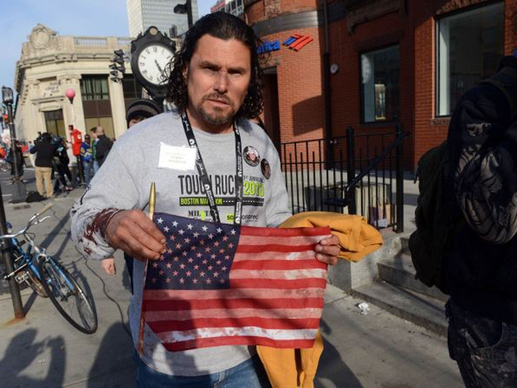 Carlos Arredondo holds a blood-soaked American flag shortly after the Boston Marathon bombing