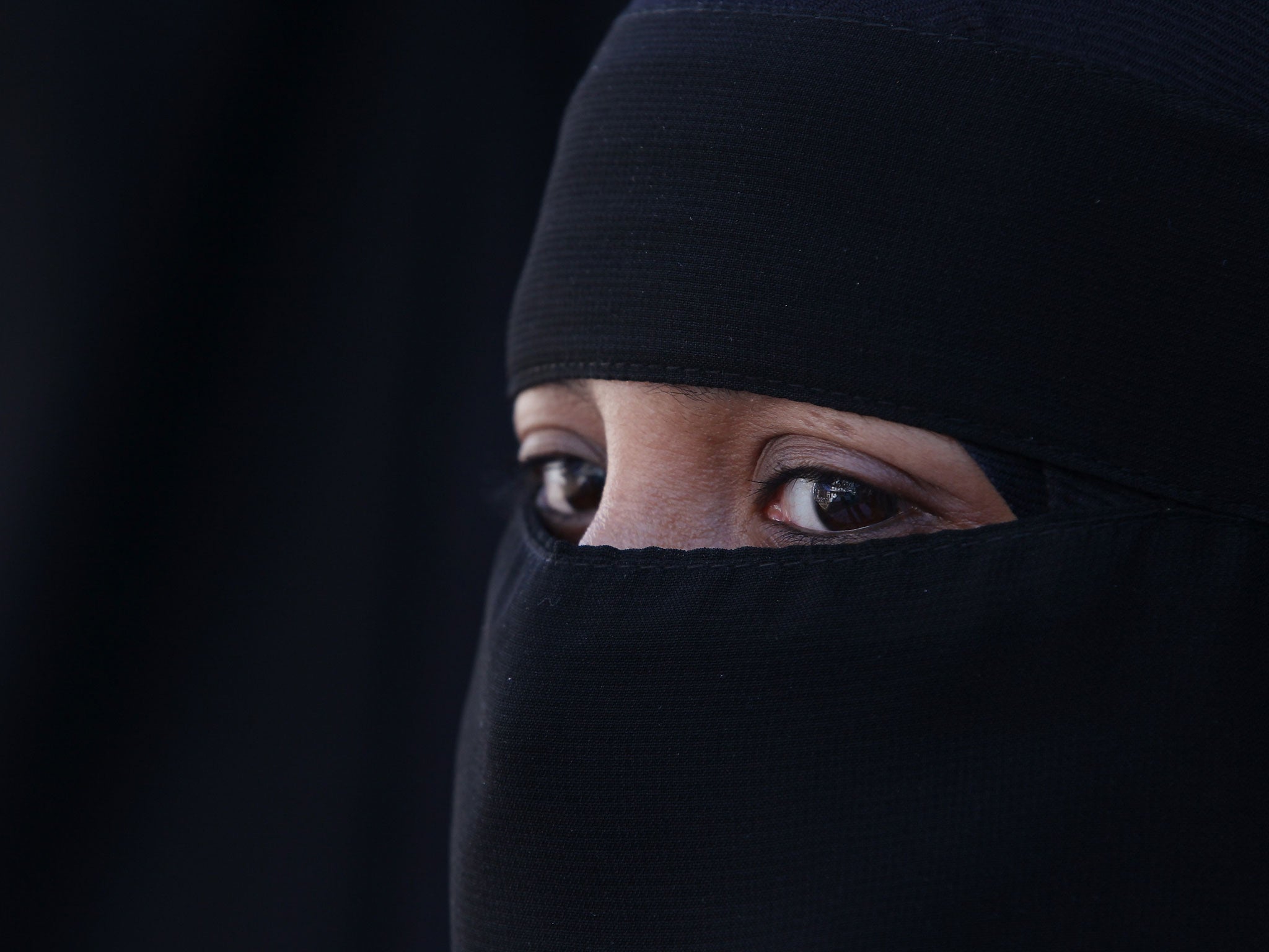 A woman wears an Islamic niqab veil stands outside the French Embassy during a demonstration on April 11, 2011 in London, England.