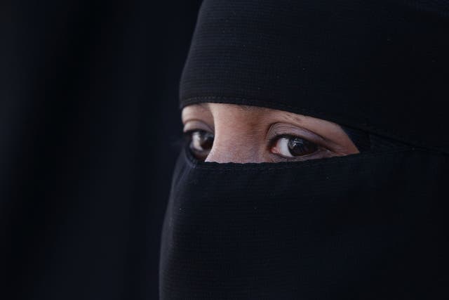 A woman wears an Islamic niqab veil stands outside the French Embassy during a demonstration on April 11, 2011 in London, England. 