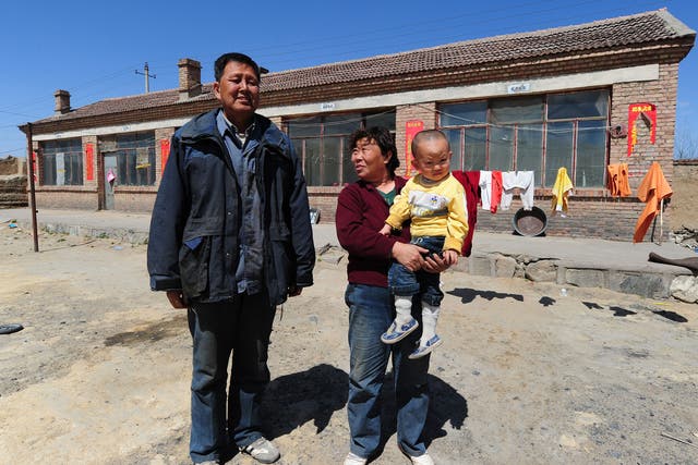 Peasant farmer Wang Tao, with his wife and grandson, outside his sparse home on April 21 , 2011near where he used to grow corn, potatoes and wheat within a stones's throw of a dumping ground for rare earths waste until toxic chemicals leaked into the water supply and poisoned his land near Baotou city in Inner Mongolia, northwest China. Farmers living near the tailings dam, a 10-square-kilometre expanse of toxic waste, say they have lost teeth and their hair has turned white while tests show the soil and water contain high levels of cancer-causing radioactive materials.