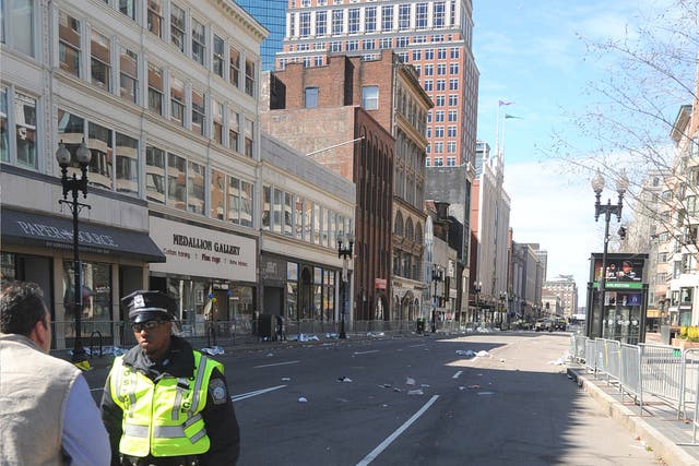 Flowers laid at a barricade on a deserted Boylston Street