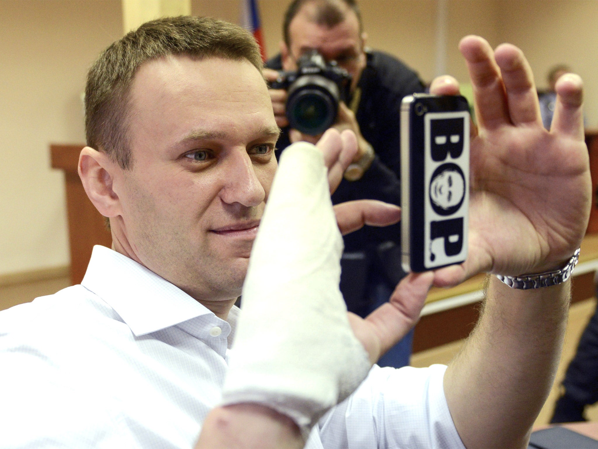 Russian opposition leader Alexei Navalny takes photos on his smartphone during his court appearance in Kirov