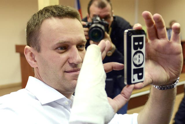 Russian opposition leader Alexei Navalny takes photos on his smartphone during his court appearance in Kirov