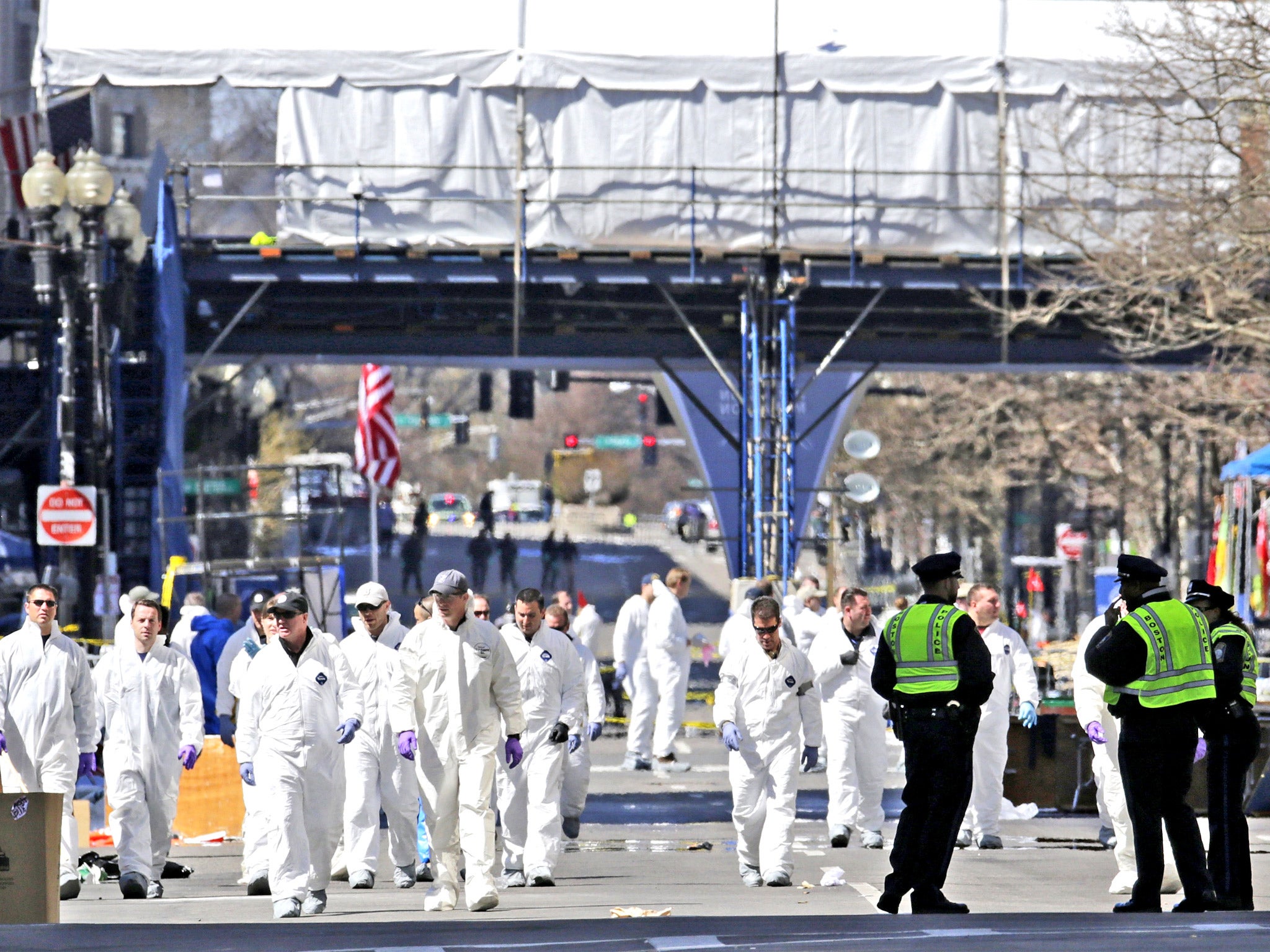 Police and investigators scour Boylston Street, near the finishing line of Monday’s Boston Marathon, yesterday
