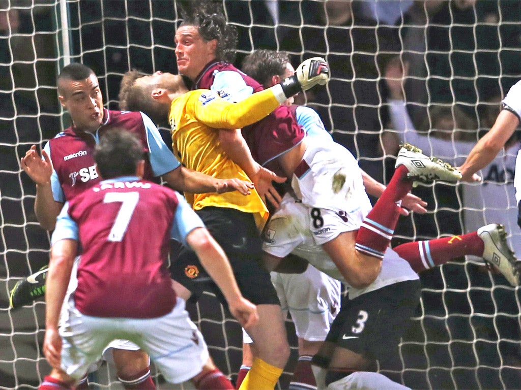 Andy Carroll of West Ham smashes into United keeper David de Gea
