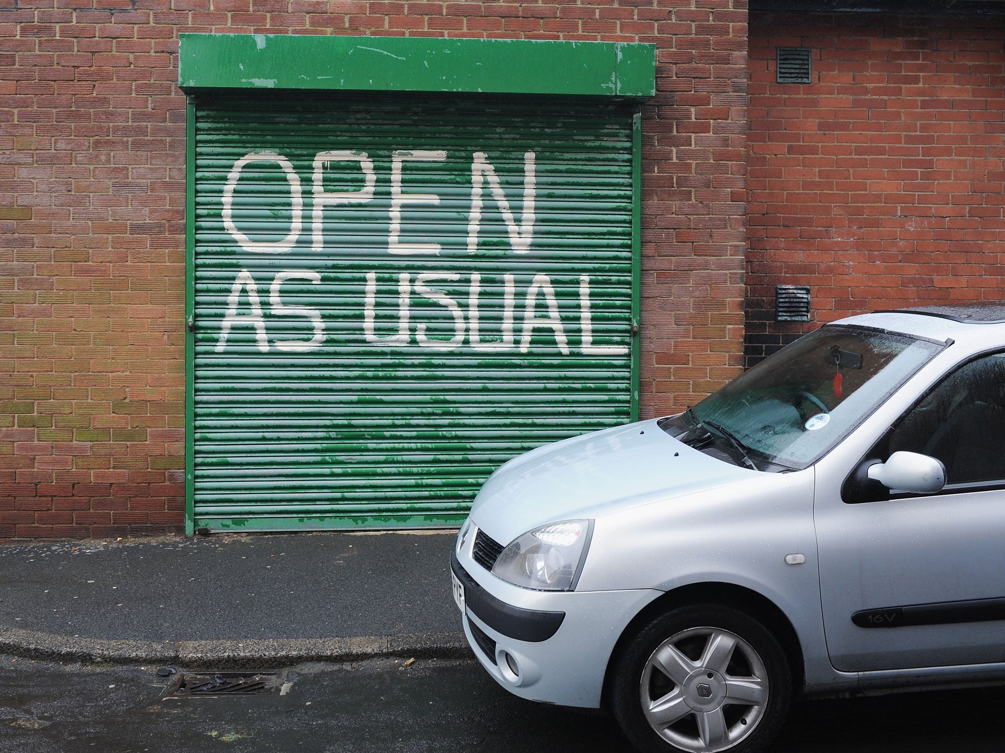 A car is parked near a garage door displaying the words 'open as usual' on a street on April 17, 2013 in Easington, England. Former miners and their families held a commemoration party for the closure of the pit at Easington Colliery; coinciding with the ceremonial funeral for Baroness Thatcher, who took on the mining union during the miners' strike which ultimately led to the closure of the mines and the loss of jobs.