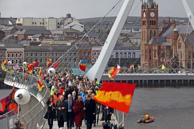 The Dalai Lama leads a symbolic walk across a peace bridge in Londonderry