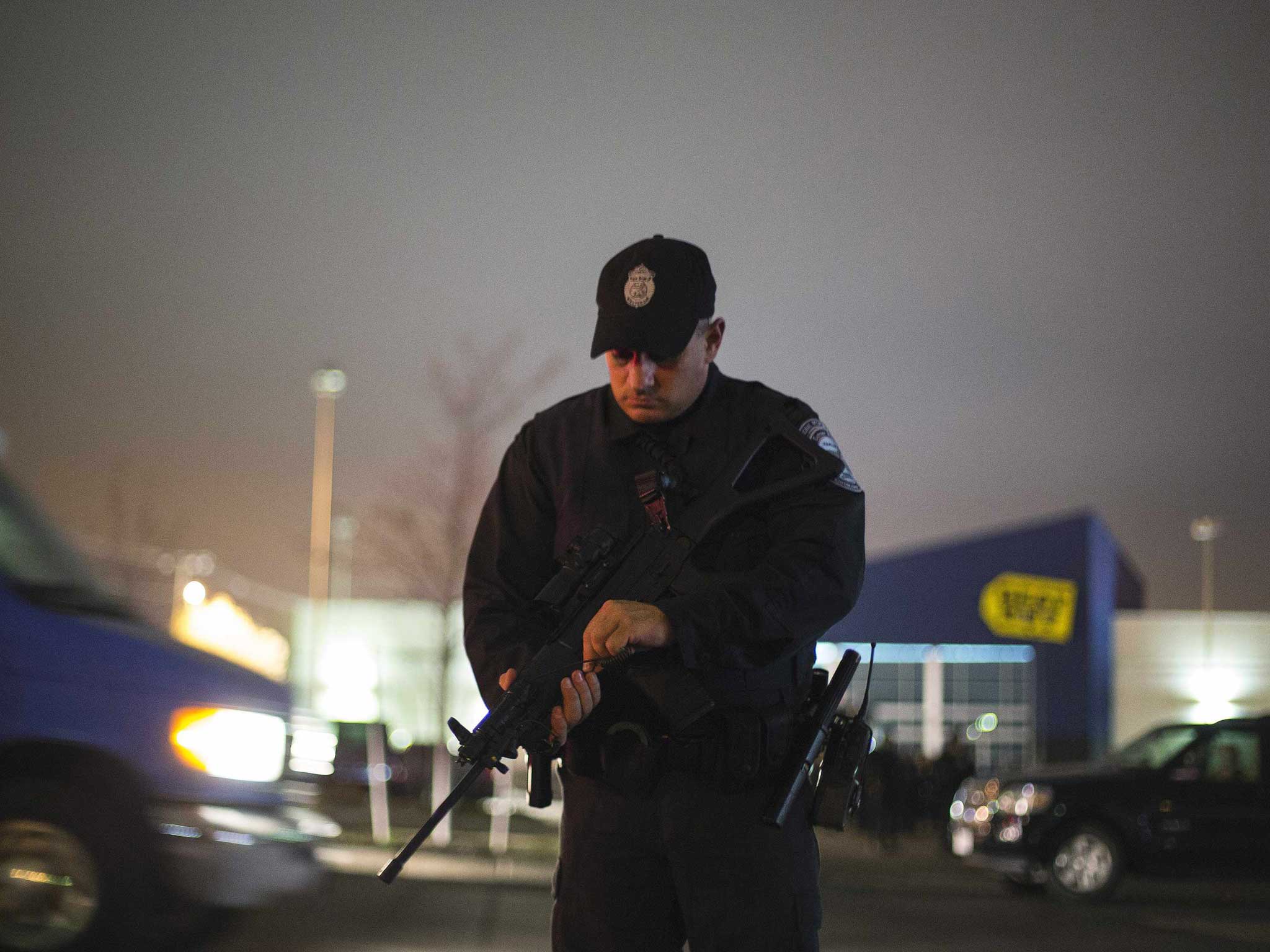 A police officer checks his rifle during a search for the two Boston bombing suspects