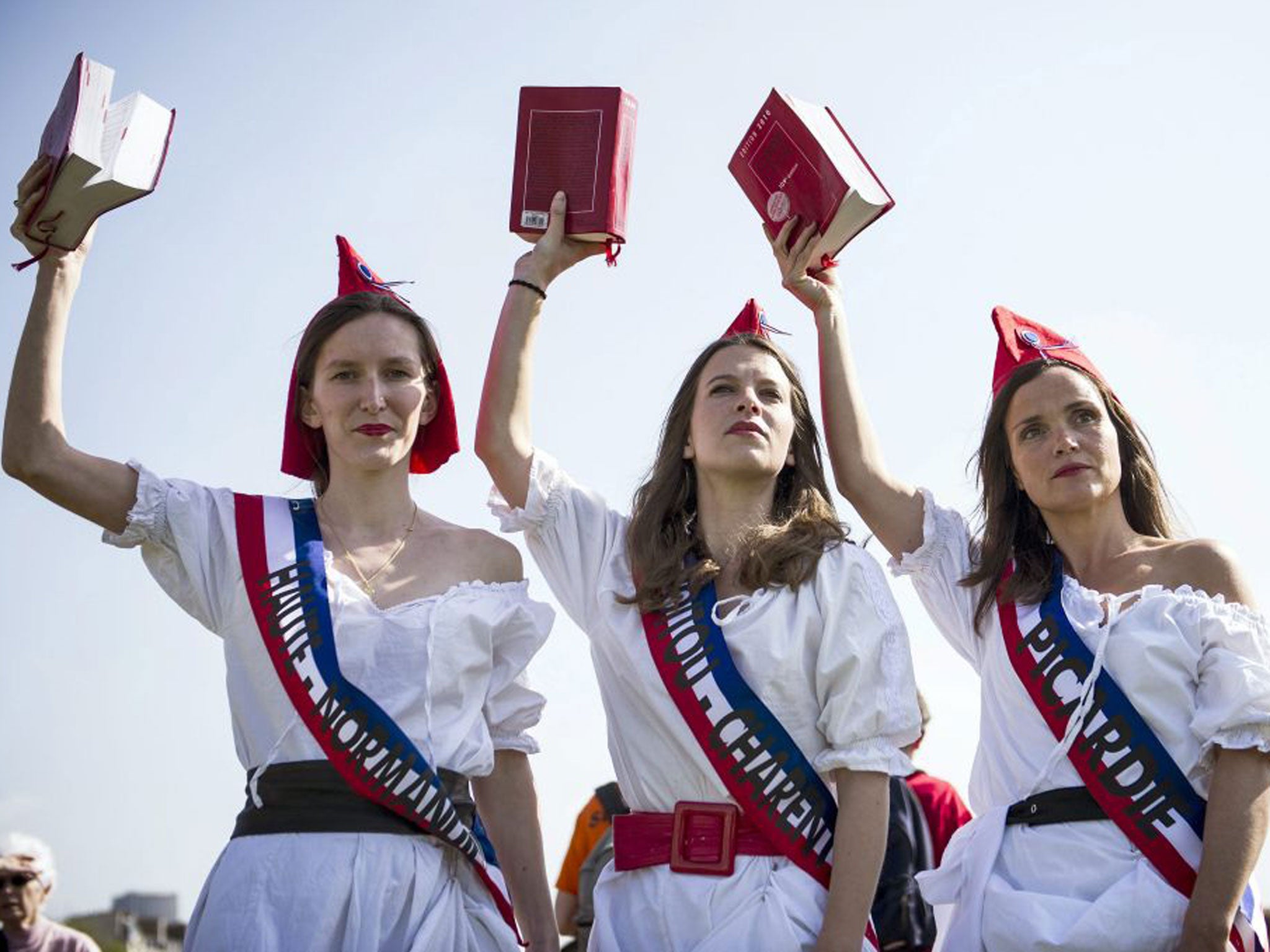 Women dressed as Marianne, a national emblem of France, hold copies of the civil code in a protest against gay marriage in Paris yesterday