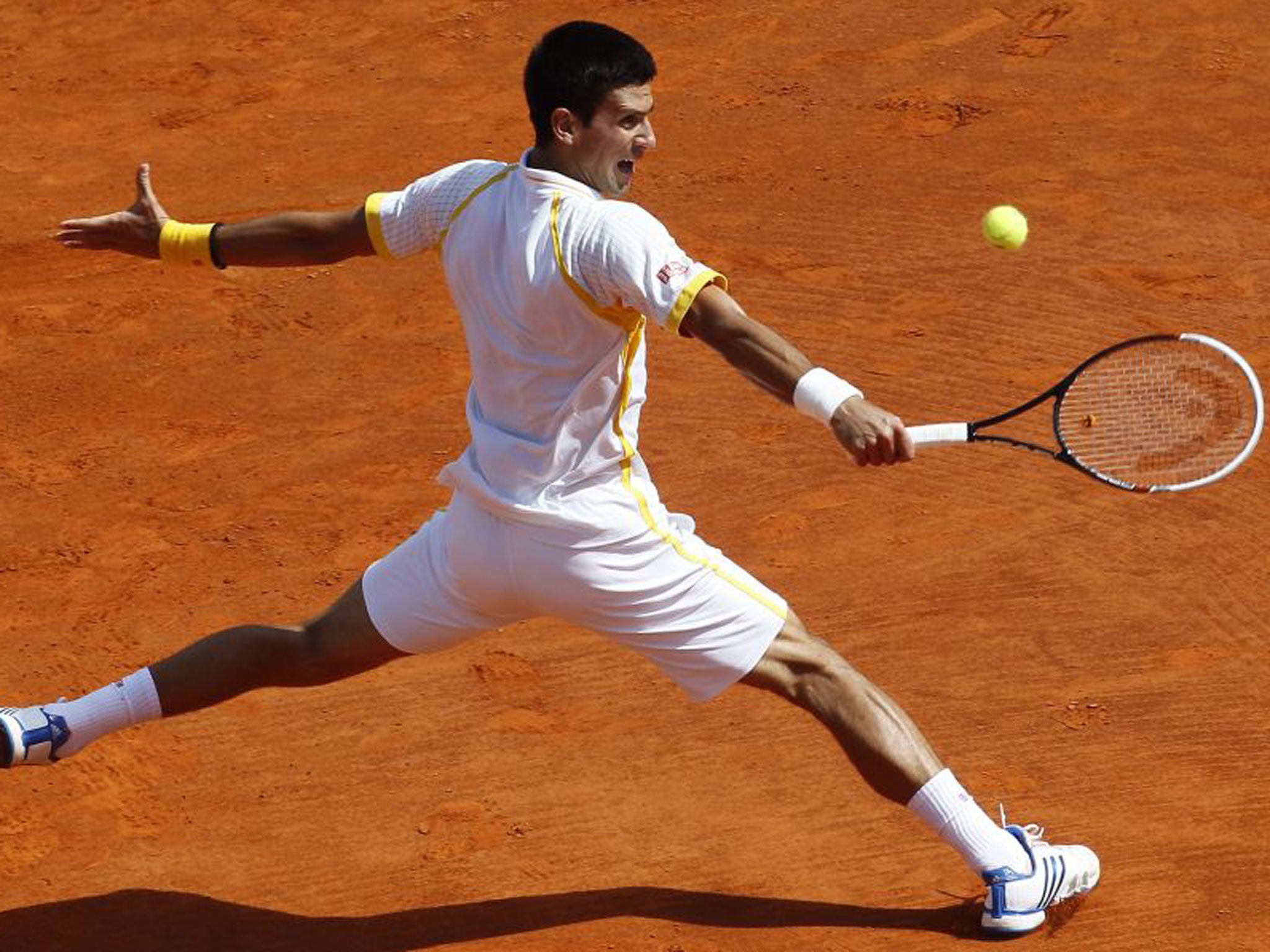 Novak Djokovic stretches to make a backhand in the Monte Carlo final