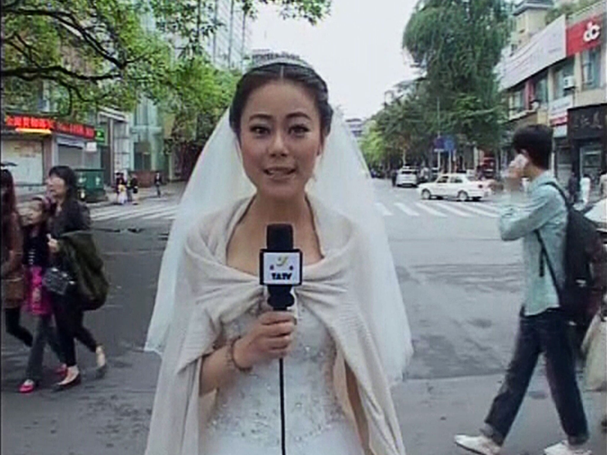 Journalist Chen Ying reports dressed in her wedding gown after an earthquake hit Ya'an, Sichuan province. Chen was having make-up applied before her wedding ceremony when the earthquake struck, and carried on with the ceremony after a quick report on the