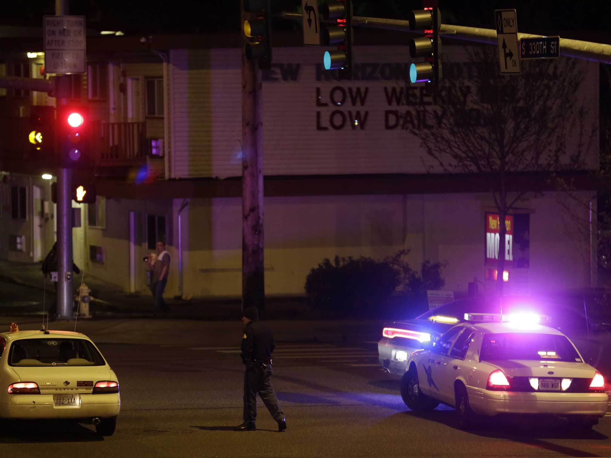 A Washington State Patrol trooper directs a driver away from a street blocked off several blocks from the scene of the shooting that police said left five people dead