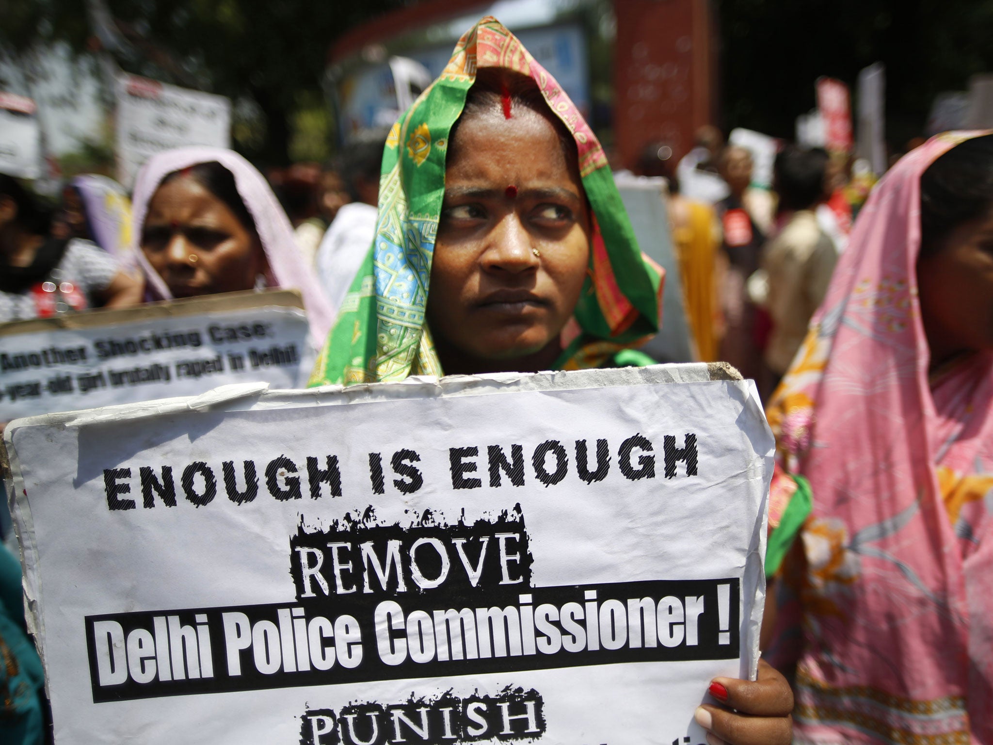 An Indian woman holds a poster as she protests with others against how Indian authorities handle sex crimes near the Parliament in New Delhi