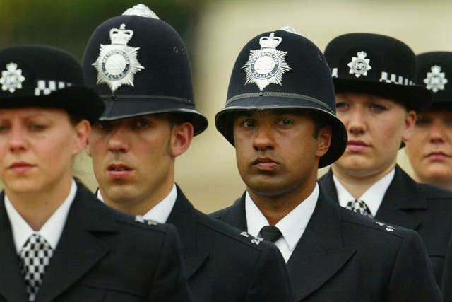 A black British police officer stands to attention during the Metropoitan Police Service's 175th Anniversary service on June 4, 2004 in London, England. The service was attended by various sections of the modern day police family.