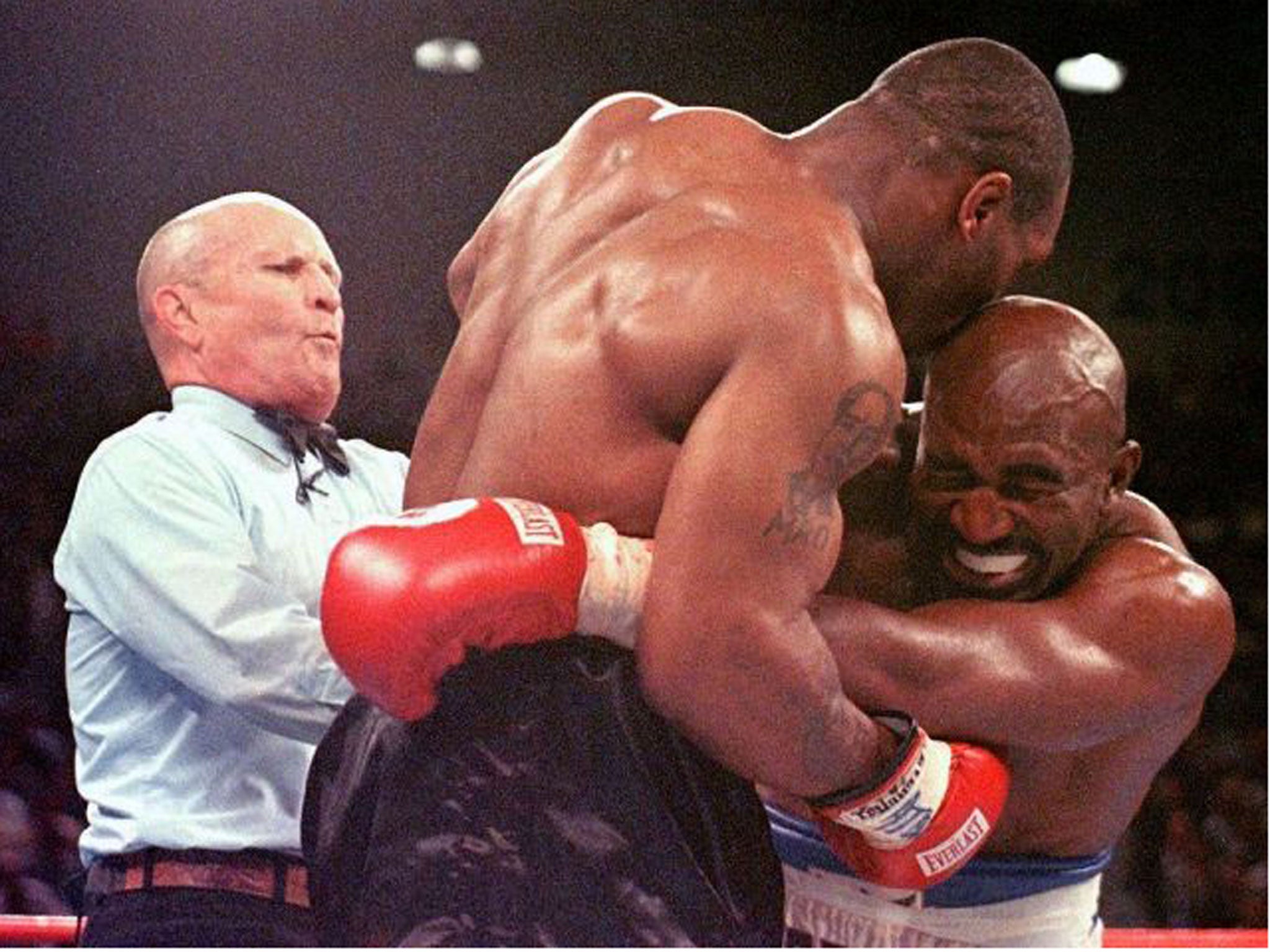 The referee Mills Lane intervenes after Mike Tyson bit Evander Holyfield (right) during their infamous encounter in June 1997