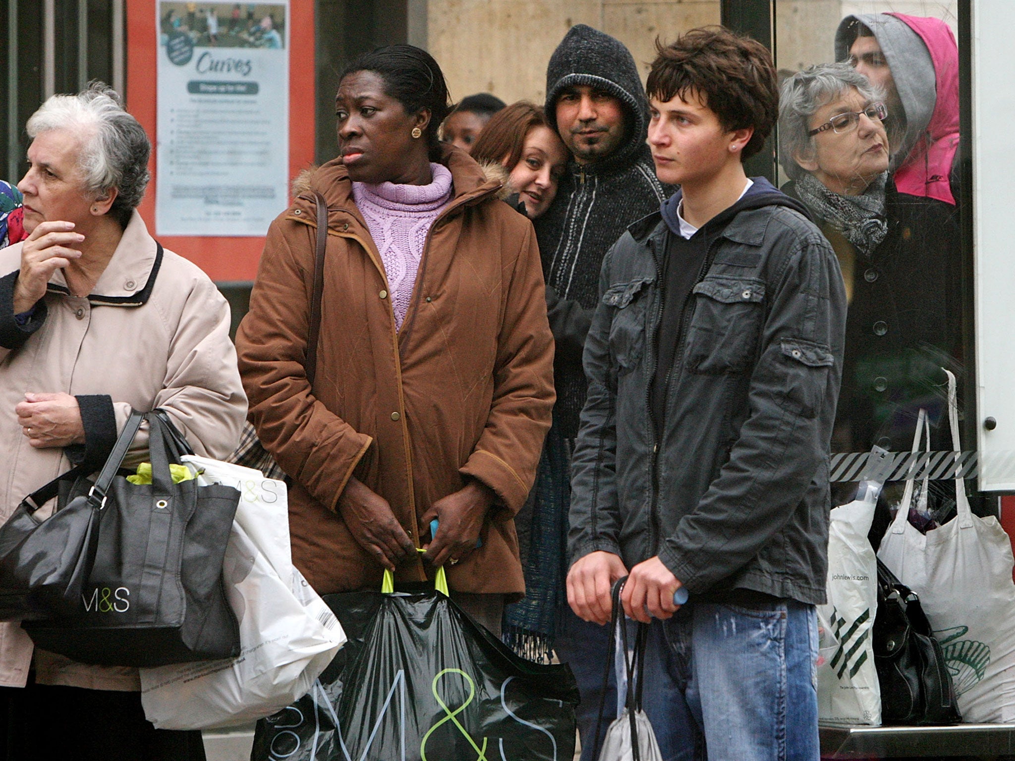 People wait for public transport at a bus-stop in Kingston Upon Thames town centre on April 19th, 2008 in London, England.