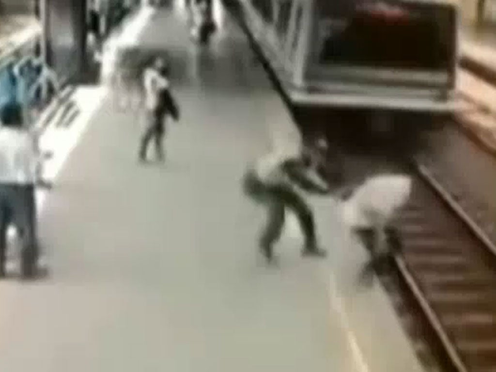 The moment the man was dragged back onto the platform by the police officer