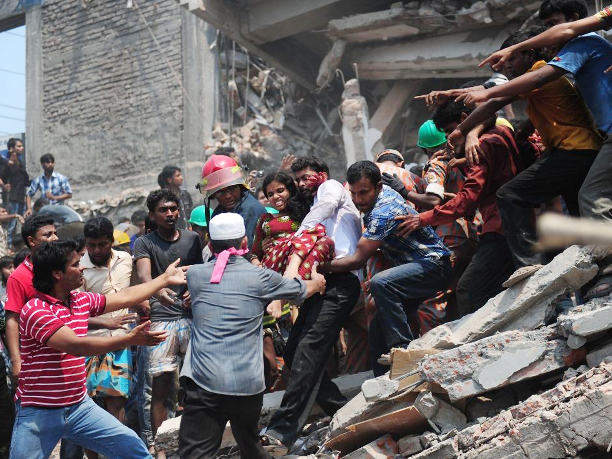 Bangladeshi volunteers evacuate an injured garment worker after an eight-storey building collapsed in Savar, on the outskirts of Dhaka