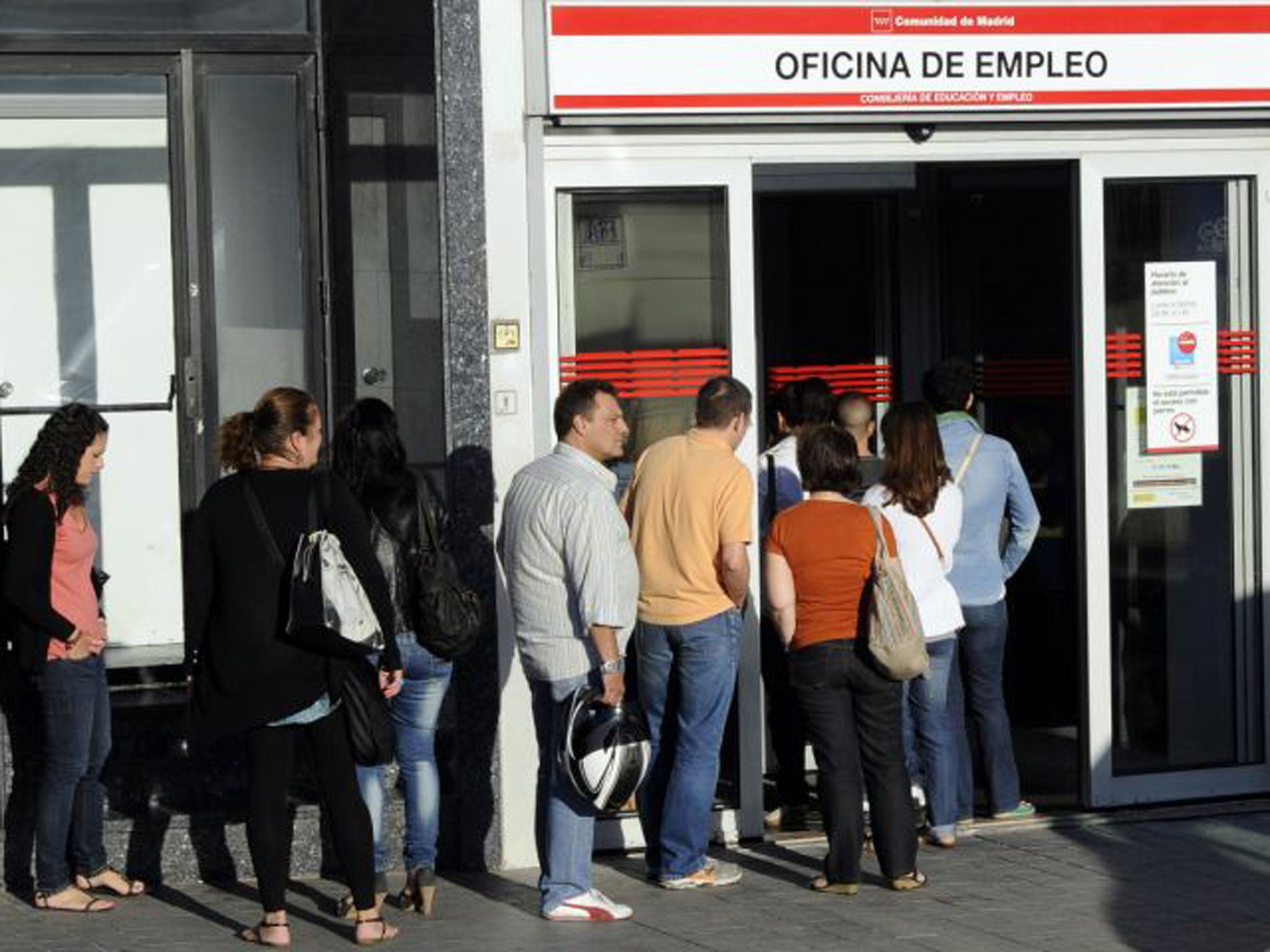 People waiting in line at a government employment office in the center of Madrid