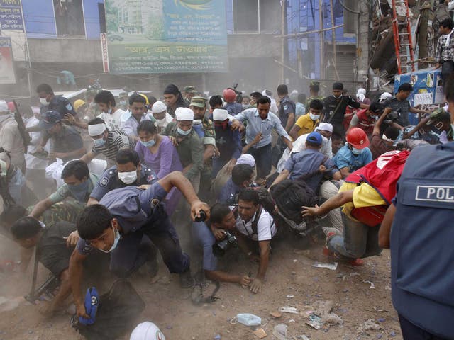 Rescue workers, army personnel, police and members of media run after they heard someone shouting that a building next to Rana Plaza is collapsing during a rescue operation in Savar